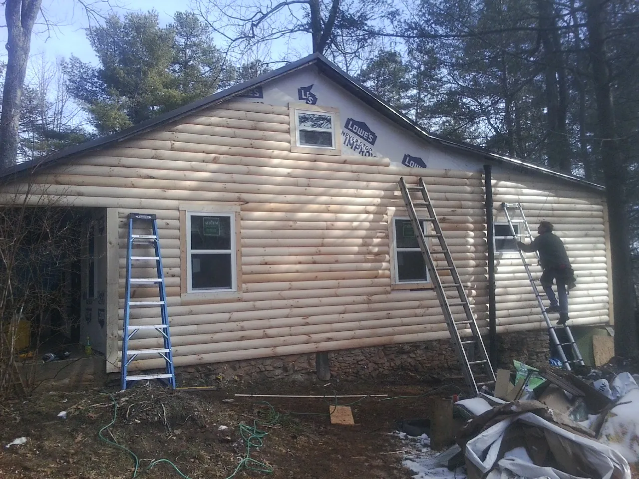 Ladders set against fresh log siding during an exterior remodel in Frankfort