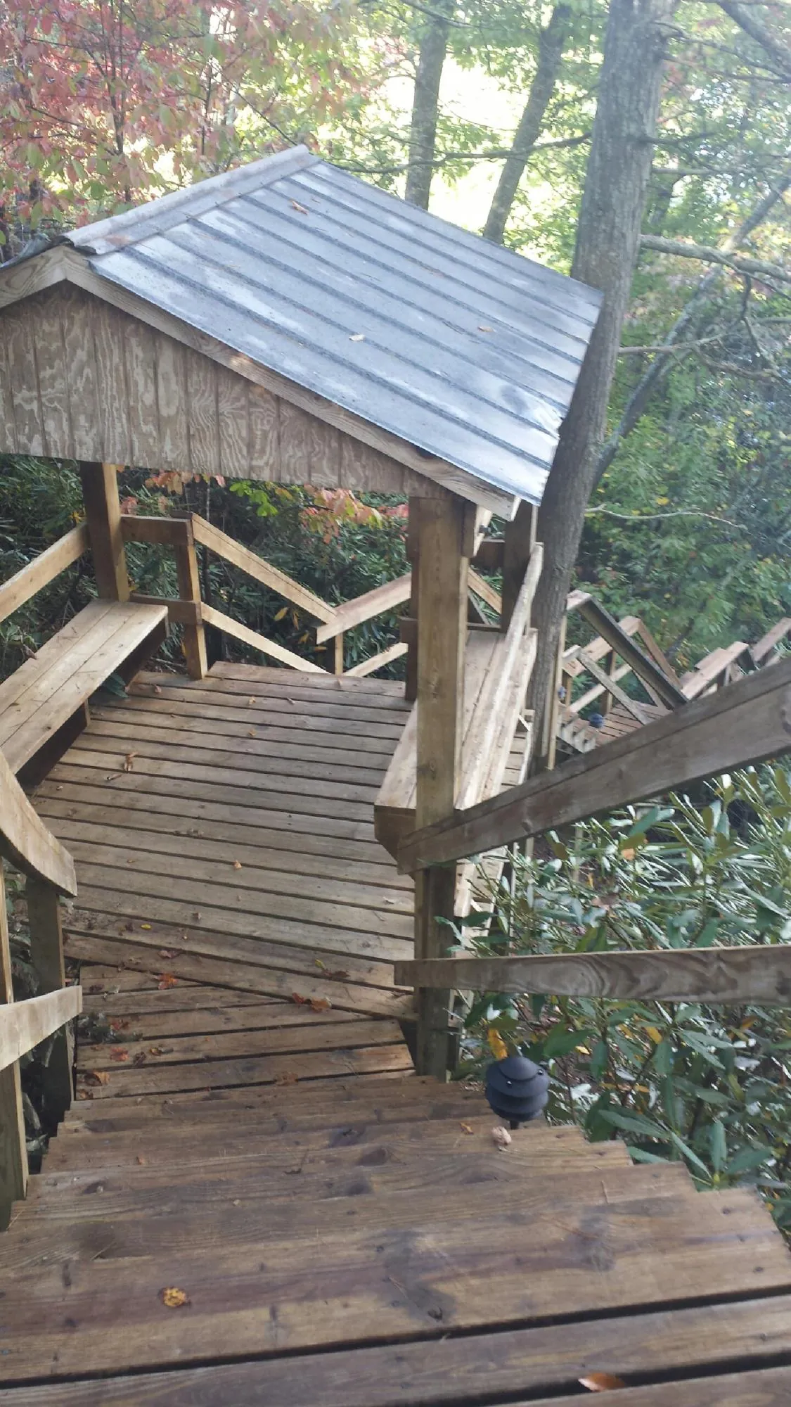 Metal roofed shelter over wooden steps on a wooded walkway — Skylight Repair & Installation work by our crew in Frankfort