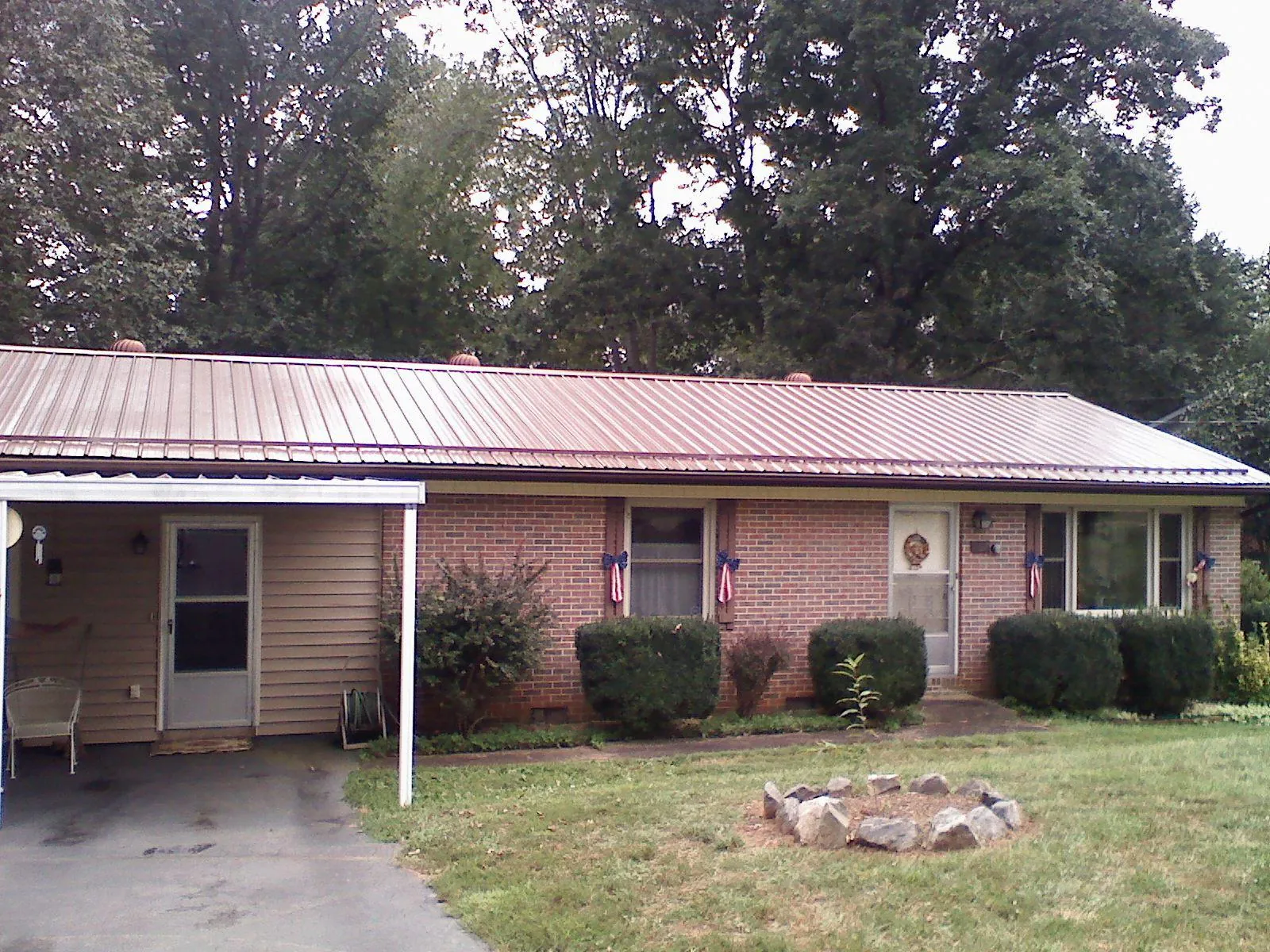 Bronze metal roof and carport on a brick ranch home — Roof Repair work by our crew in Frankfort
